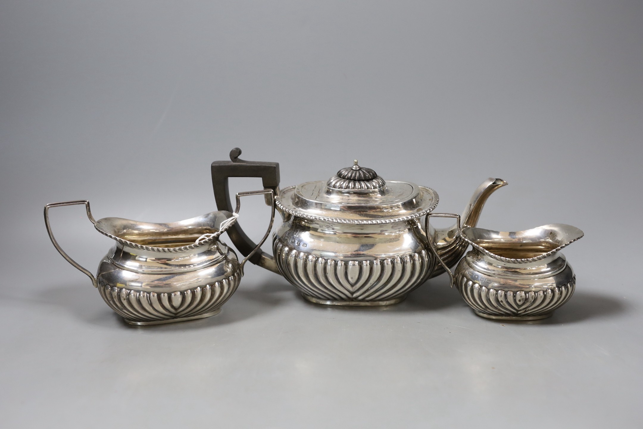 A matched late Victorian demi-fluted silver three piece tea set, Birmingham, 1896/7